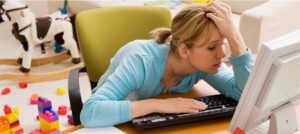 Photo of woman at computer with hand on head